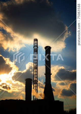 High exhaust chimney against blue sky 75063588