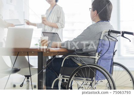 一個坐在輪椅上在辦公室里工作的人 75063793