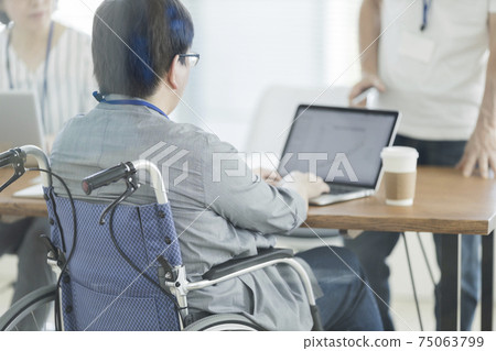一個坐在輪椅上在辦公室里工作的人 75063799