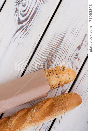 French bread on wooden background, top view. French bread on wooden background, top view. 75063848