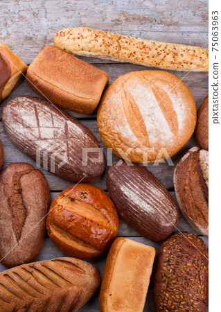 Variety of organic bread on wooden background. 75063963