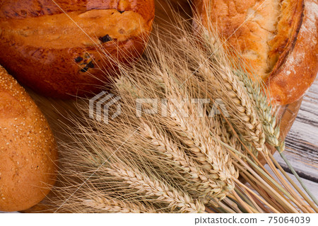 Fresh bread with wheat ears close up. 75064039