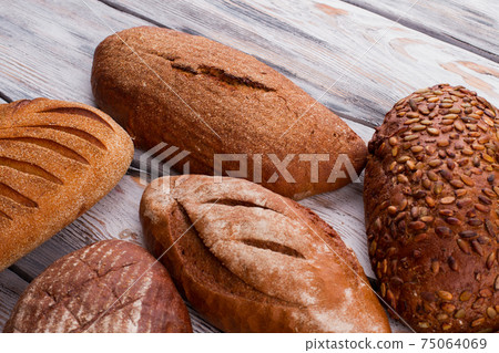 Delicious bread loaves on wooden background. Delicious bread loaves on wooden background. 75064069