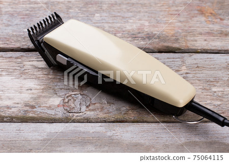 Electric hair clipper on wooden background. 75064115