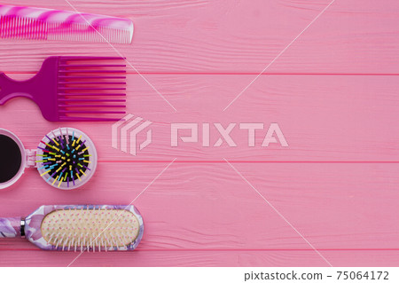 Colorful hair brushes on pink background. 75064172