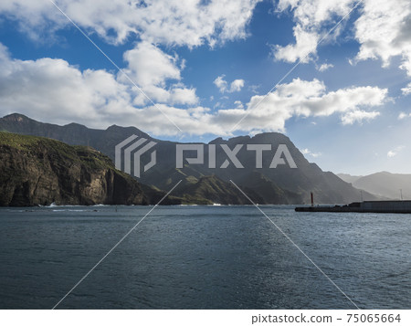 View of Tamadaba green mountains, ocean and lighthouse from port of Puerto de las Nieves, traditional fishing village. Agaete, Gran Canaria, Canary Islands, Spain 75065664