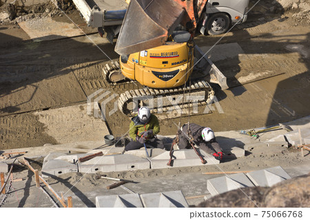 河流維修工作:砌築工匠安裝護岸的工作現場 河流維修工作:砌築工匠安裝護岸的工作現場 75066768