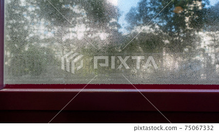 Scenery seen from a dew-condensed winter window 75067332