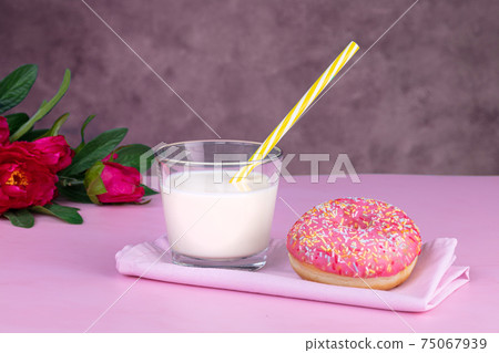 Pink donut with a glass of milk 75067939