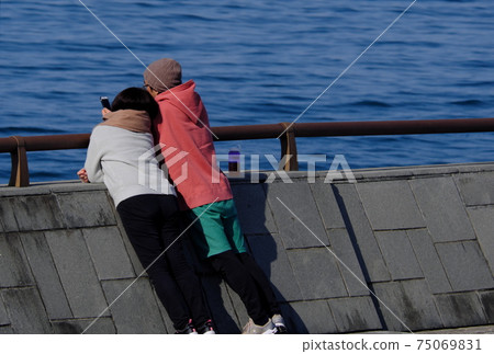 A couple snuggling up to the sea A couple snuggling up to the sea 75069831