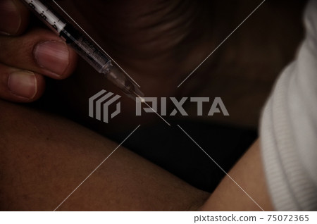 A person who injects with a syringe 75072365