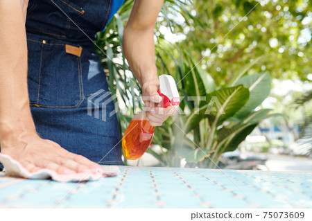 Spraying detergent on cafe table 75073609