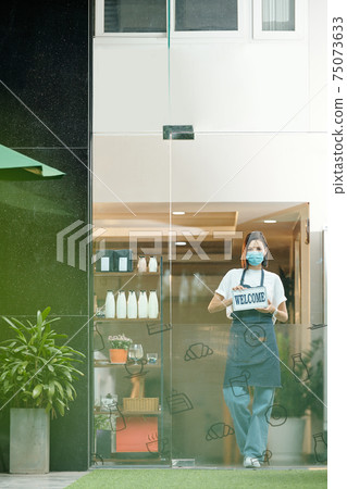 Woman welcoming clients in store Woman welcoming clients in store 75073633