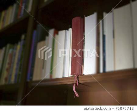 Brown leather Holy Bible on shelf with other books Brown leather Holy Bible on shelf with other books 75075718