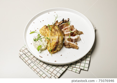 Duck breast with cabbage steak with cheese sauce. Delicious restaurant dish on a round plate on a checkered napkin. Poultry recipes 75076946