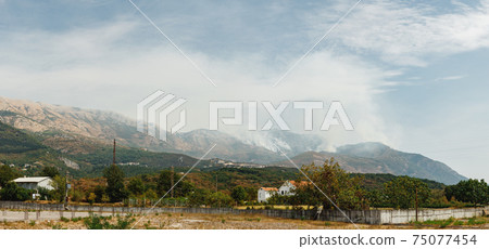 White smoke in the mountains of Montenegro. Large source of fire ignition in smoke. White smoke in the mountains of Montenegro. Large source of fire ignition in smoke. 75077454