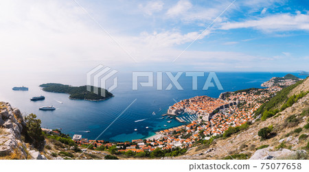 Aerial top view on the old city of Dubrovnik, from the observation deck on the mountain above the city. Film location. The view of the city is based on the Royal Harbor. 75077658