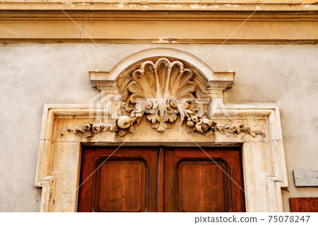 An architectural element above the entrance, made in the style of a bas-relief. 75078247