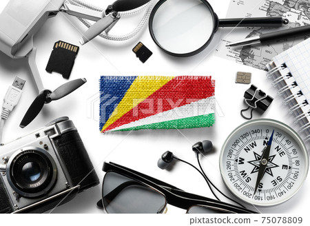 Flag of Seychelles and travel accessories on a white background. Flag of Seychelles and travel accessories on a white background. 75078809