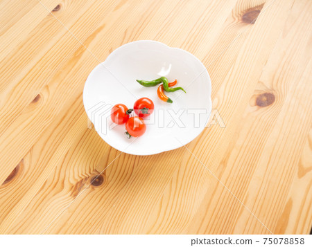 Pepper tomatoes and chili peppers on white on a white wooden table 75078858