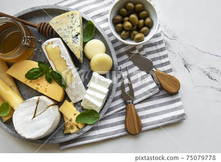 Various types of cheese, grapes, honey and snacks Various types of cheese, grapes, honey and snacks 75079778