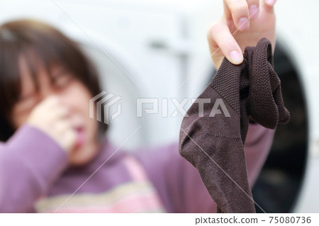 一個家庭主婦在洗衣服時丈夫的襪子聞起來太多 一個家庭主婦在洗衣服時丈夫的襪子聞起來太多 75080736