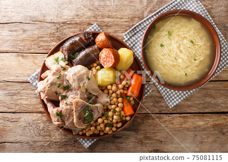 Cocido is a traditional chickpea based stew with chicken, beef, blood sausage, chorizo and pork belly close-up on a plate. Horizontal top view Cocido is a traditional chickpea based stew with chicken, beef, blood sausage, chorizo and pork belly close-up on a plate. Horizontal top view 75081115