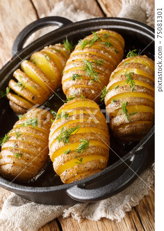 hasselback potatoes are thinly sliced potatoes that are baked to golden brown perfection with butter and garlic closeup in a pan. Vertical hasselback potatoes are thinly sliced potatoes that are baked to golden brown perfection with butter and garlic closeup in a pan. Vertical 75081301