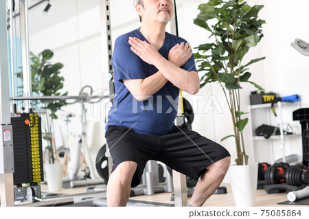 White-haired senior man squatting in the gym 75085864