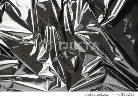 Plastic wrap. Black shiny film bag pattern. Transparent dark cellophane texture. Creative crumpled background. 75086238