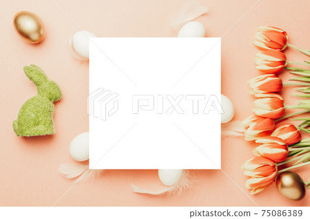 Easter banner. Golden, white colour egg in basket with spring tulips, feathers on pastel pink background in Happy Easter decoration. Foil minimalist egg design, modern top view template. 75086389
