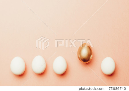 Easter background. Golden, white colour egg on pastel pink background in Happy Easter decoration. Spring holiday top view concept. Easter background. Golden, white colour egg on pastel pink background in Happy Easter decoration. Spring holiday top view concept. 75086740