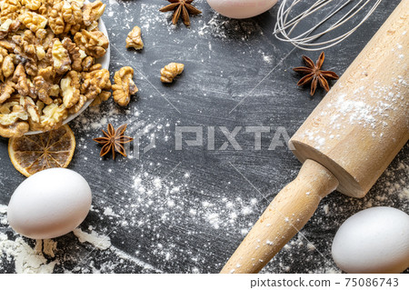 Bakery food. Fresh food ingredients: flour, eggs, nut and star anise, orange on black chalkboard background for bread. Cooking flat lay with copy space. Top view. Baking concept. Bakery food. Fresh food ingredients: flour, eggs, nut and star anise, orange on black chalkboard background for bread. Cooking flat lay with copy space. Top view. Baking concept. 75086743