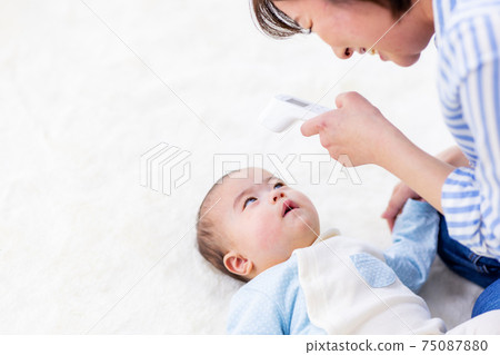 Mother measuring body temperature of baby 75087880