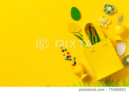 Felt Easter decorations and sweets on yellow background Felt Easter decorations and sweets on yellow background 75088881