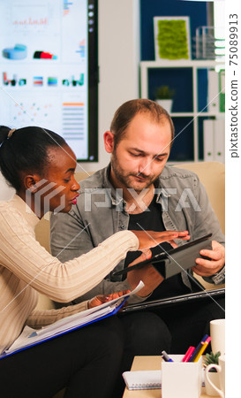 Diverse businesspeople analysing financial project during corporate meeting Diverse businesspeople analysing financial project during corporate meeting 75089913