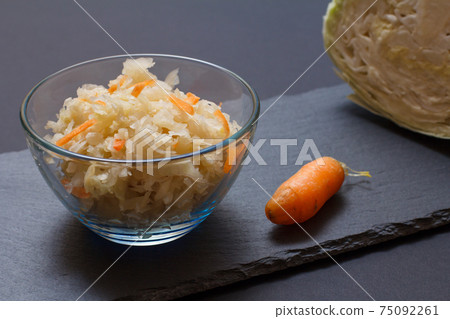 Fermented cabbage with herbs and spices in glass bowl on the black background Fermented cabbage with herbs and spices in glass bowl on the black background 75092261