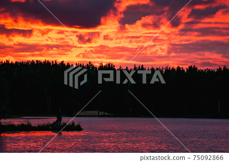 Red sunset with clouds over lake in forest in Red sunset with clouds over lake in forest in 75092866