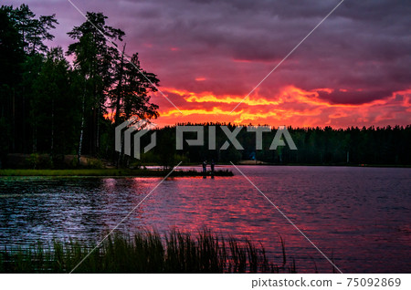 Red sunset with clouds over lake in forest in 75092869