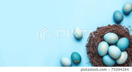 Easter eggs in nest on blue background. Easter eggs in nest on blue background. 75094264