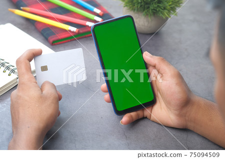 Man hand holding credit card and using smart phone shopping online Man hand holding credit card and using smart phone shopping online 75094509