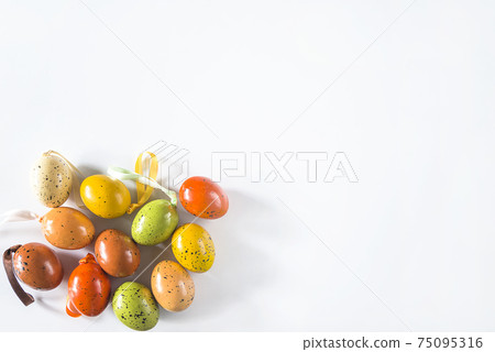 Happy Easter greeting card. Multicolored easter eggs on white background. Space for text, flat lay Happy Easter greeting card. Multicolored easter eggs on white background. Space for text, flat lay 75095316
