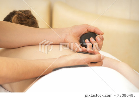 Masseur massaging back of woman 75096493