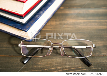 Glasses and stack of hardcover books Glasses and stack of hardcover books 75096970