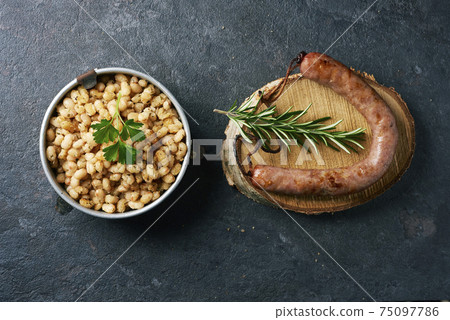 fried sausage and white beans typical of catalonia 75097786