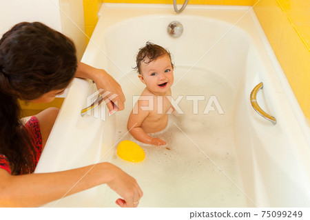 Smiling kid with foam and soap bubbles in bathroom. Smiling kid with foam and soap bubbles in bathroom. 75099249