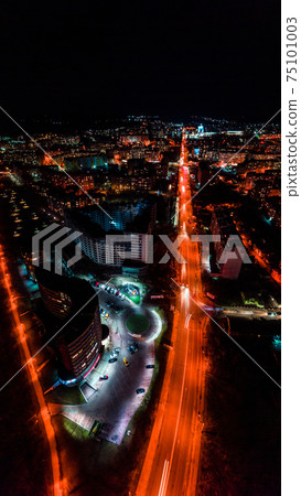 Panorama of night aerial view of the city of Ivano-Frankivsk, bright lights from cars and night lighting of the city. 75101003