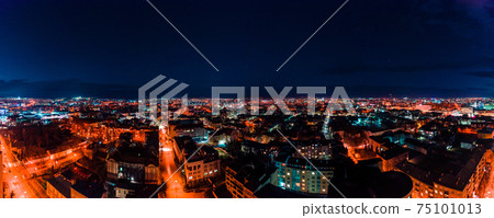 Panorama of night aerial view of the city of Ivano-Frankivsk, bright lights from cars and night lighting of the city. 75101013
