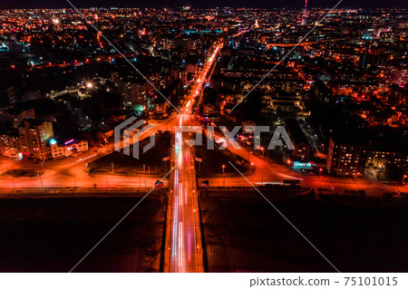 Panorama of night aerial view of the city of Ivano-Frankivsk, bright lights from cars and night lighting of the city. 75101015