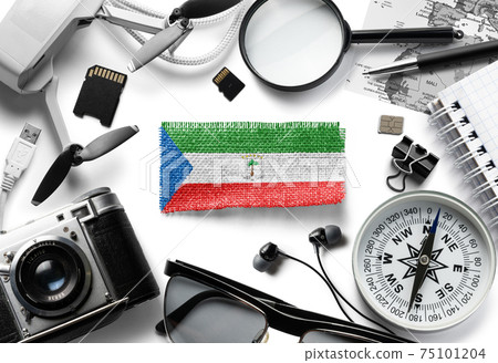 Flag of Equatorial Guinea and travel accessories on a white background. Flag of Equatorial Guinea and travel accessories on a white background. 75101204